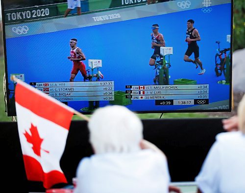 JOHN WOODS / WINNIPEG FREE PRESS
Josephine Leddy, grandmother of Canadian Triathlete Tyler Mislawchuck waves her flag and cheers him on as he races at the Tokyo Olympics at his parents house in Oak Bluff Sunday, July 25, 2021. 

Reporter: Sawatzky