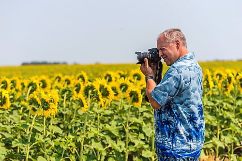 MIKAELA MACKENZIE / WINNIPEG FREE PRESS

Maurice Regaudie, who's driving from Saskatchewan to Ontario, takes photos of sunflower fields at the longitudinal centre of Canada highway pullout on Tuesday, July 27, 2021.  Standup.
Winnipeg Free Press 2021.