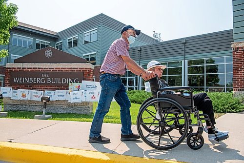 ALEX LUPUL / WINNIPEG FREE PRESS  

Mel Fages pushes his wife Arlene in her wheelchair, outside of Arlene's care home on Tuesday, July, 27, 2021. Arlene has dementia, and Mel visits her at the Simkin Centre. The centre has painted blue circles on the grounds, so that families can socially distance from other groups while visiting their loved ones 

Reporter: Kevin Rollason