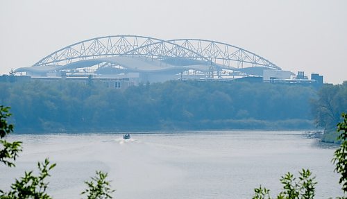 MIKE DEAL / WINNIPEG FREE PRESS
A motor boat zips along the Red River where it runs along River Road in St. Vital with smoke hazed IG Field rising in the distance.
210729 - Thursday, July 29, 2021.