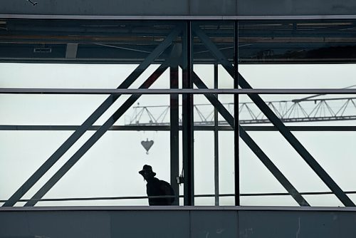 ALEX LUPUL / WINNIPEG FREE PRESS  

A person is seen in silhouette while walking across an above-ground walkway in downtown Winnipeg on Thursday, July, 29, 2021.