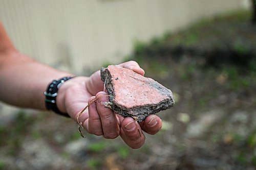 MIKAELA MACKENZIE / WINNIPEG FREE PRESS

Chris Black holds up a broken piece of old floor tile on the site of the St. Boniface Industrial School (this area would have been the front yard originally) in Winnipeg on Thursday, July 29, 2021. For Dylan story.
Winnipeg Free Press 2021.