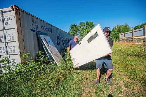 MIKAELA MACKENZIE / WINNIPEG FREE PRESS

Roger Stearns (left) and Ace Burpee carry materials over to work on the newest enclosure at Black Bear Rescue Manitoba near Stonewall on Sunday, July 25, 2021. For Eva story.
Winnipeg Free Press 2021.