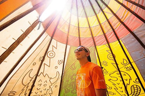 MIKE SUDOMA / Winnipeg Free Press
Artist Jordan Stranger stands inside the tipi he created which dipicts the seven sacred teachings at Fort Whyte Friday afternoon. July 30, 2021