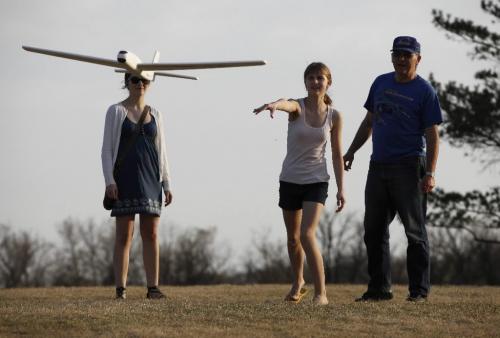 BORIS.MINKEVICH@FREEPRESS.MB.CA  100418 BORIS MINKEVICH / WINNIPEG FREE PRESS King's Park -Rebecca Craig,13, (centre) launches a toy glider as sister Amy,16, and dad John assist. Warm weather drove Winnipegers out to local parks Sunday evening
