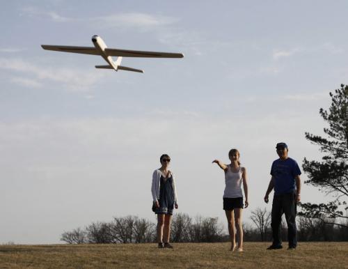 BORIS.MINKEVICH@FREEPRESS.MB.CA  100418 BORIS MINKEVICH / WINNIPEG FREE PRESS King's Park -Rebecca Craig,13, (centre) launches a toy glider as sister Amy,16, and dad John assist. Warm weather drove Winnipegers out to local parks Sunday evening