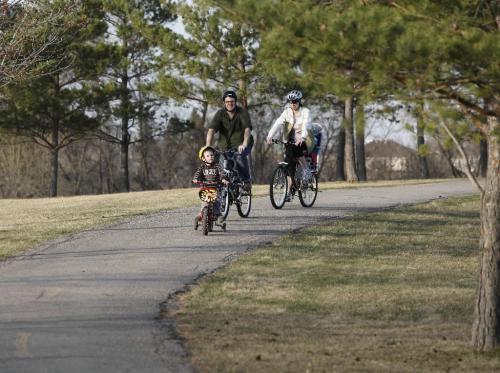 BORIS.MINKEVICH@FREEPRESS.MB.CA  100418 BORIS MINKEVICH / WINNIPEG FREE PRESS Kings Park -Spencer Strijack,2, leads his parents Stuart and Christine, and little sister Evelyn,2,(in basket behind mom but not seen). The family spent the evening cycling through the park.