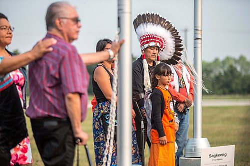 MIKAELA MACKENZIE / WINNIPEG FREE PRESS

Sagkeeng First Nation chief Derrick Henderson and his granddaughter, Marcella Oman (eight), listen to a memorial song to remember the children lost at residential schools while lowering the flags to half mast at a commemoration of the 150th anniversary of the making of Treaty No. 1 at the Lower Fort Garry National Historic Site on Tuesday, Aug. 3, 2021. For Gabrielle Piche story.
Winnipeg Free Press 2021.