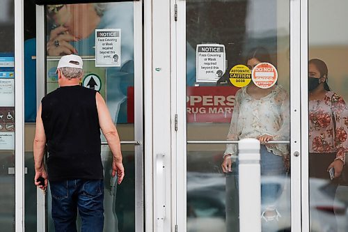 JOHN WOODS / WINNIPEG FREE PRESS
A person walks past mask signage as they enter a Pembina Highway drug store Wednesday, August 4, 2021. Starting Saturday the province has removed mask and other COVID-19 mandates.

Reporter: ?