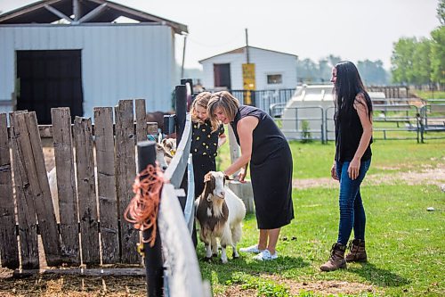 MIKAELA MACKENZIE / WINNIPEG FREE PRESS

Macyn Comeault (left), Carissa Comeault, and Lucy Sloan take a look at the goats at Lil' Steps Wellness Farm in St. Malo on Friday, Aug. 6, 2021. For Sabrina story.
Winnipeg Free Press 2021.