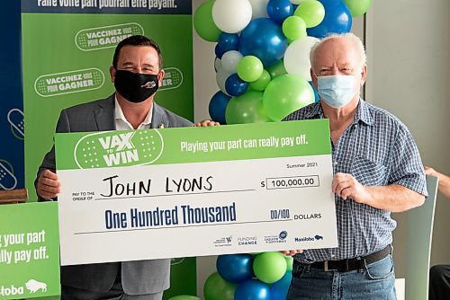 ALEX LUPUL / WINNIPEG FREE PRESS  

Crown Services Minister Jeff Wharton hands a cheque to John Lyons, one of the Vax to Win Lottery winners, at the Leila Avenue vaccination site on August 17, 2021.