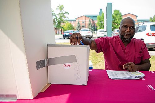 ALEX LUPUL / WINNIPEG FREE PRESS  

Healthcare worker Emerson Brewster places his vote in a ballot box. CUPE is holding a strike vote for healthcare support staff on August 18, 2021.