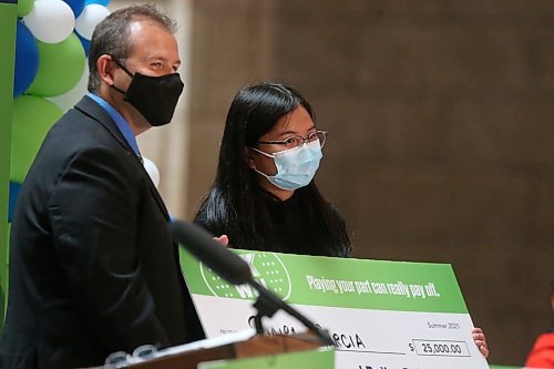 WINNIPEG FREE PRESS/SHANNON VANRAES
Advanced Education Minister Wayne Ewasko hands a giant check to Vax to Win scholarship recipient Shaira Garcia at the Manitoba Legislative Building August 23, 2021.