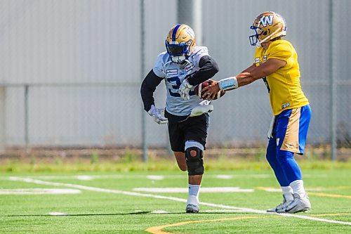 MIKAELA MACKENZIE / WINNIPEG FREE PRESS

Quarterback Zach Collaros fakes a handoff to Andrew Harris at Bombers practice in Winnipeg on Wednesday, Aug. 25, 2021. For Mike Sawatzky story.
Winnipeg Free Press 2021.