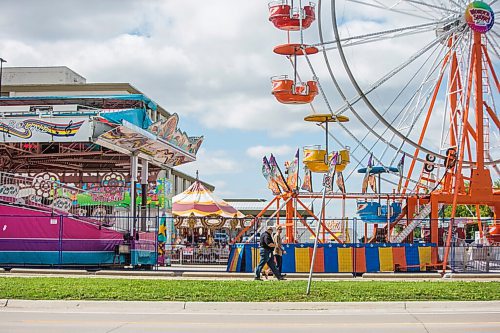 MIKAELA MACKENZIE / WINNIPEG FREE PRESS

Folks walk past colourful rides set up in the Victoria Inn parking lot in Winnipeg on Wednesday, Aug. 25, 2021. The fair will be opening at noon on Thursday. Standup.
Winnipeg Free Press 2021.