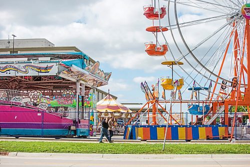 MIKAELA MACKENZIE / WINNIPEG FREE PRESS

Folks walk past colourful rides set up in the Victoria Inn parking lot in Winnipeg on Wednesday, Aug. 25, 2021. The fair will be opening at noon on Thursday. Standup.
Winnipeg Free Press 2021.