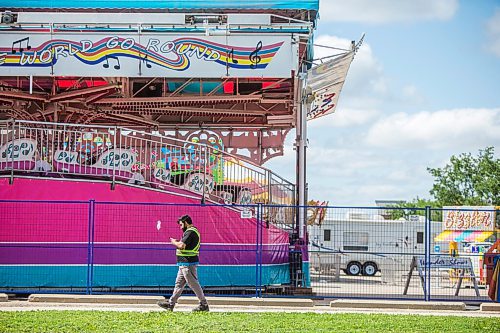 MIKAELA MACKENZIE / WINNIPEG FREE PRESS

Folks walk past colourful rides set up in the Victoria Inn parking lot in Winnipeg on Wednesday, Aug. 25, 2021. The fair will be opening at noon on Thursday. Standup.
Winnipeg Free Press 2021.