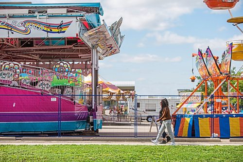 MIKAELA MACKENZIE / WINNIPEG FREE PRESS

Folks walk past colourful rides set up in the Victoria Inn parking lot in Winnipeg on Wednesday, Aug. 25, 2021. The fair will be opening at noon on Thursday. Standup.
Winnipeg Free Press 2021.