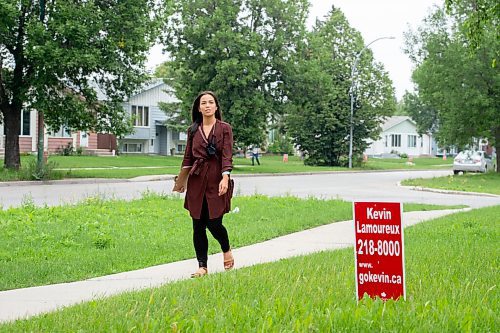 MIKE SUDOMA / Winnipeg Free Press
NDP MLA for Winnipeg North, Melissa Chung-Mowat walks by a sign for opposition, Kevin Lamoureux , while campaigning Friday
August 27, 2021