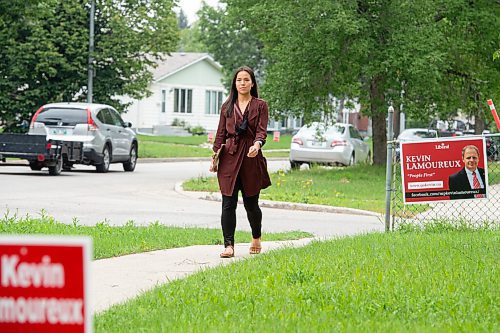 MIKE SUDOMA / Winnipeg Free Press
NDP MLA for Winnipeg North, Melissa Chung-Mowat walks by a sign for opposition, Kevin Lamoureux , while campaigning Friday
August 27, 2021