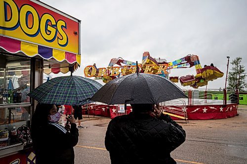 MIKE SUDOMA / Winnipeg Free Press
Two fair attendees hold umbrellas at the Red River Exhibitions Autumn Fair, Friday night
August 27, 2021