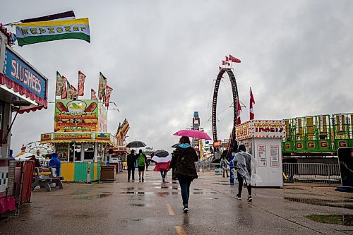 MIKE SUDOMA / Winnipeg Free Press
An attendee wilding a pink umbrella walks the Red River Exhibitions Autumn Fair, Friday night
August 27, 2021