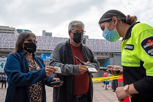 ALEX LUPUL / WINNIPEG FREE PRESS  

Dennis Weedon and Carolyn Pinsonneault have their proof of vaccination scanned in order to enter Shaw Park for the Unite 150 concert on August, 28, 2021.