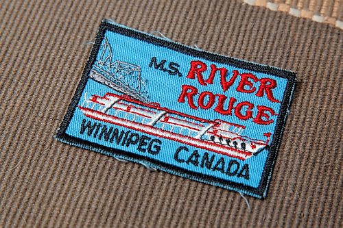 MIKE DEAL / WINNIPEG FREE PRESS
River Rouge badge/crest.
Craig Kraft, 61, has a modest collection of items associated with Winnipeg's riverboat era; postcards, buttons, boarding passes etc. from the various ships that used to parade up and down the Red, the River Rouge, Paddlewheel, Paddlewheel Princess etc.
See David Sanderson story
210831 - Tuesday, August 31, 2021.