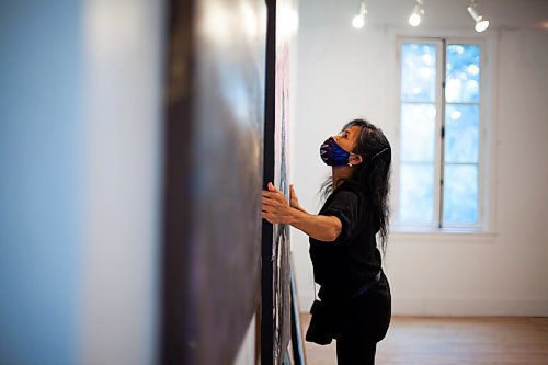 Daniel Crump / Winnipeg Free Press. Phoebe Man takes down art that was on display after Gerryfest 2021 at the St. Norbert Art Centre. September 2, 2021.