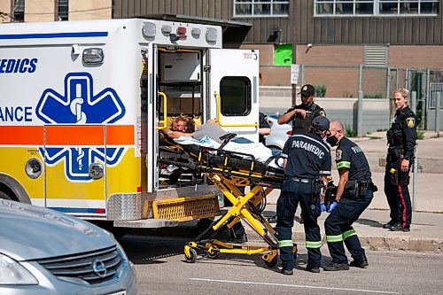 Daniel Crump / Winnipeg Free Press. Winnipeg Police officers and members of the Winnipeg Fire Paramedic Service tend to a handcuffed and hooded person. A heavy police presence could be seen in the area around Logan Avenue And Martha Street around noon on Friday. September 3, 2021.