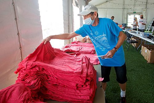 MIKE DEAL / WINNIPEG FREE PRESS
Volunteer Dennis Lang packs up a kit for a registered half-marathoner on the last day that participants in this weekends Manitoba Marathon can pick up their bibs, t-shirts and medal from the Tailgate tent by IG Field Friday afternoon.
210903 - Friday, September 03, 2021.