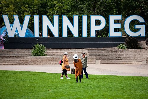 Daniel Crump / Winnipeg Free Press. (L to R) Ghongrat Inthirath , Khankham Keosavang , and Khanong Khamta take selfies in front of the Winnipeg sign at the Forks on Saturday afternoon. September 4, 2021.