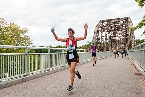 MIKE SUDOMA / Winnipeg Free Press
Marathon runner, Mingdi cheers as she makes her way across the bridge by the Bridge Drive In restaurant as she participates in the Manitoba Marathon Sunday morning
September 5, 2021