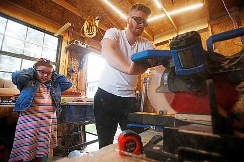 JOHN WOODS / WINNIPEG FREE PRESS
Nora Proutt, 6, covers her ears as her dad Matt cuts wood at their home workshop in Selkirk Wednesday, September 8, 2021. Matt and Kaelyn Proutt have started M+K Wood Co., a business that started as a cabinet supplier but now turns out custom, wooden kennels for dogs.

Reporter: ?