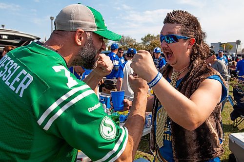 Daniel Crump / Winnipeg Free Press. Riders fan Andrew Walker and Bombers fan Neal Einarson pretend to fight   during the tailgate at IG Field prior to the Banjo Bowl, Saturday afternoon. September 11, 2021.