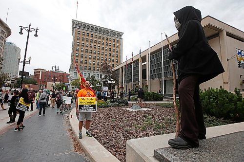 JOHN WOODS / WINNIPEG FREE PRESS
A person dressed as the Grim Reaper looks on as about 150 anti-maskers/vaxxers gathered at the MB Legislature and walked to the City Hall in protest against COVID-19 vaccinations and masks in Winnipeg Monday, September 13, 2021. 

Reporter: Silva