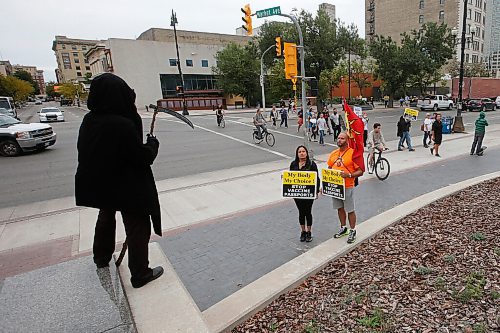 JOHN WOODS / WINNIPEG FREE PRESS
A person dressed as the Grim Reaper looks on as about 150 anti-maskers/vaxxers gathered at the MB Legislature and walked to the City Hall in protest against COVID-19 vaccinations and masks in Winnipeg Monday, September 13, 2021. 

Reporter: Silva