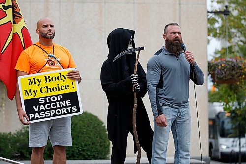 JOHN WOODS / WINNIPEG FREE PRESS
A person dressed as the Grim Reaper looks on as organizer Shaun Zimmer speaks to about 150 anti-maskers/vaxxers gathered at the MB Legislature and walked to the City Hall in protest against COVID-19 vaccinations and masks in Winnipeg Monday, September 13, 2021. 

Reporter: Silva