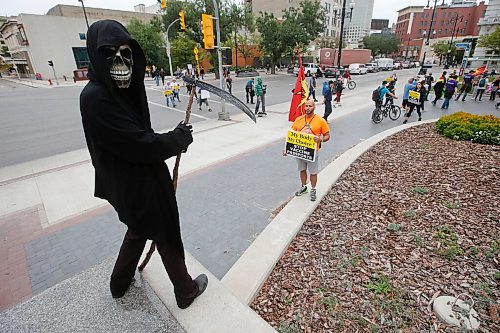 JOHN WOODS / WINNIPEG FREE PRESS
A person dressed as the Grim Reaper looks on as about 150 anti-maskers/vaxxers gathered at the MB Legislature and walked to the City Hall in protest against COVID-19 vaccinations and masks in Winnipeg Monday, September 13, 2021. 

Reporter: Silva