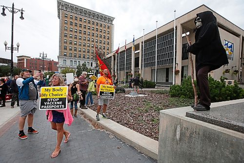 JOHN WOODS / WINNIPEG FREE PRESS
A person dressed as the Grim Reaper looks on as about 150 anti-maskers/vaxxers gathered at the MB Legislature and walked to the City Hall in protest against COVID-19 vaccinations and masks in Winnipeg Monday, September 13, 2021. 

Reporter: Silva