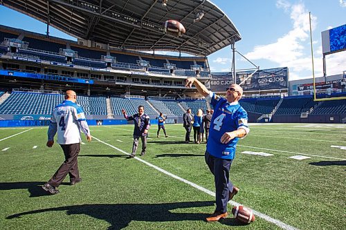MIKE DEAL / WINNIPEG FREE PRESS
Premier Kelvin Goertzen throws a football around on IG Field after the ceremony Tuesday afternoon.
Premier Kelvin Goertzen, Wade Miller, president and CEO, Winnipeg Football Club and Dayna Spiring, chair, board of directors, Winnipeg Football Club along with other dignitaries were on hand at IG Field Tuesday afternoon, for the signing-in of the 2019 Grey Cup Champions into the Order of the Buffalo Hunt.
210914 - Tuesday, September 14, 2021.