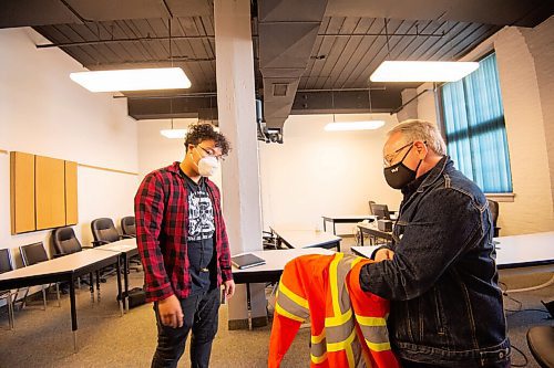 MIKE SUDOMA / Winnipeg Free Press
Workwear designer, Bob Axelrod, presents artist Isaiah Binns with a piece of high vis workwear with a design based around the themes of reconciliation and missing/murdered indigenous children done by Binns embroidered on the sleeve.
September 17, 2021