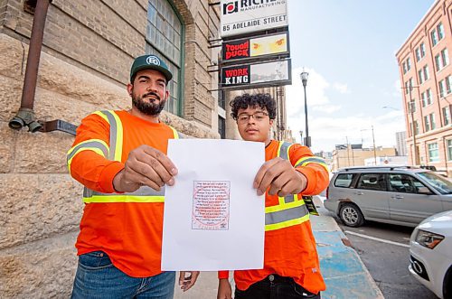 MIKE SUDOMA / Winnipeg Free Press
Young artist, Isaiah Binns (right), and his former graphic design teacher, Mathew Reis, hold up a passage written by Binns on the theme of reconciliation. The passage will be featured on the hang tags of Tough Duck garments in the near future 
September 17, 2021