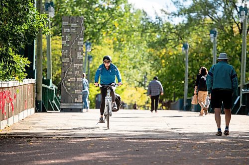 MIKE SUDOMA / Winnipeg Free Press
Melanie Janzen enjoys the warm afternoon weather as she bikes across a footbridge at The Forks Friday afternoon
September 17, 2021