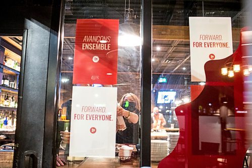 MIKAELA MACKENZIE / WINNIPEG FREE PRESS

Campaign manager Rebecca Parkinson reaches to put up signage at Winnipeg South Centre Liberal incumbent Jim Carr's election night viewing party at Fionn MacCool's in Winnipeg on Monday, Sept. 20, 2021.  For Danielle story.
Winnipeg Free Press 2021.