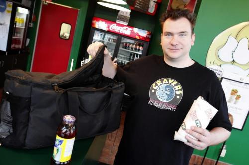 BORIS.MINKEVICH@FREEPRESS.MB.CA  100513 BORIS MINKEVICH / WINNIPEG FREE PRESS Ryan Dowd runs a business called Cravers All Night Delivery. Here he poses for a photo at the Pita Pit, one of the places his clients order food from.