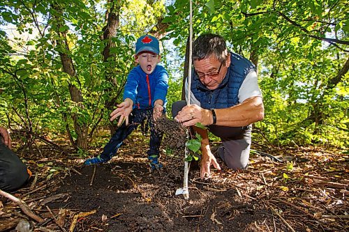 MIKE DEAL / WINNIPEG FREE PRESS
Finley Stalker, 5, with his grandfather plants a poplar sapling in the riparian forest along the Assiniboine River as the Assiniboine Park Conservancy Autumn Adventures Nature Tots program celebrates National Tree Day.
210922 - Wednesday, September 22, 2021.