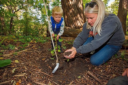 MIKE DEAL / WINNIPEG FREE PRESS
Theo Fehr, 2, with his mother, Rachel, plants a poplar sapling in the riparian forest along the Assiniboine River as the Assiniboine Park Conservancy Autumn Adventures Nature Tots program celebrates National Tree Day.
210922 - Wednesday, September 22, 2021.