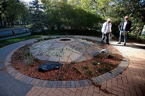 JOHN WOODS / WINNIPEG FREE PRESS
Sylvia Genaille, councillor and elder at the National Centre for Truth and Reconciliation, collects sage in their medicine garden as Jesse Boiteau, senior archivist, looks on at the centre in Winnipeg Wednesday, September 22, 2021. 

Reporter: Martin