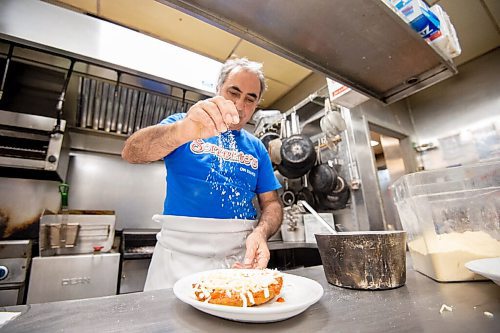 MIKE SUDOMA / Winnipeg Free Press
Gerry Lomonaco, owner of the Sorrentos location on Ellice Ave, sprinkles parmesan atop an order of Chicken Parmesan, a staple at the restaurant.
September 24, 2021